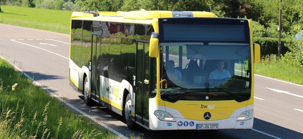 gelber Bus fährt auf Landstraße