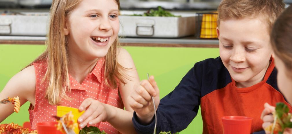 Titelbild des Flyers Schulmensen gut geplant Kindergruppe während des Essens