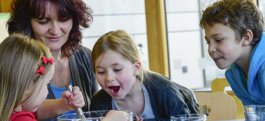 Kinder und Erzieherin beim Essen