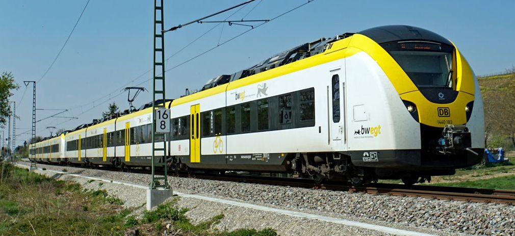 Flyerbild Bahnfahrt 2024 weiß-gelber Zug während der Fahrt